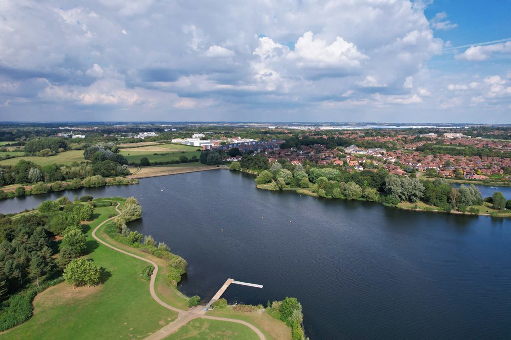 Aerial photo of Caldecotte Lake, England, showcasing serene water and lush greenery.
