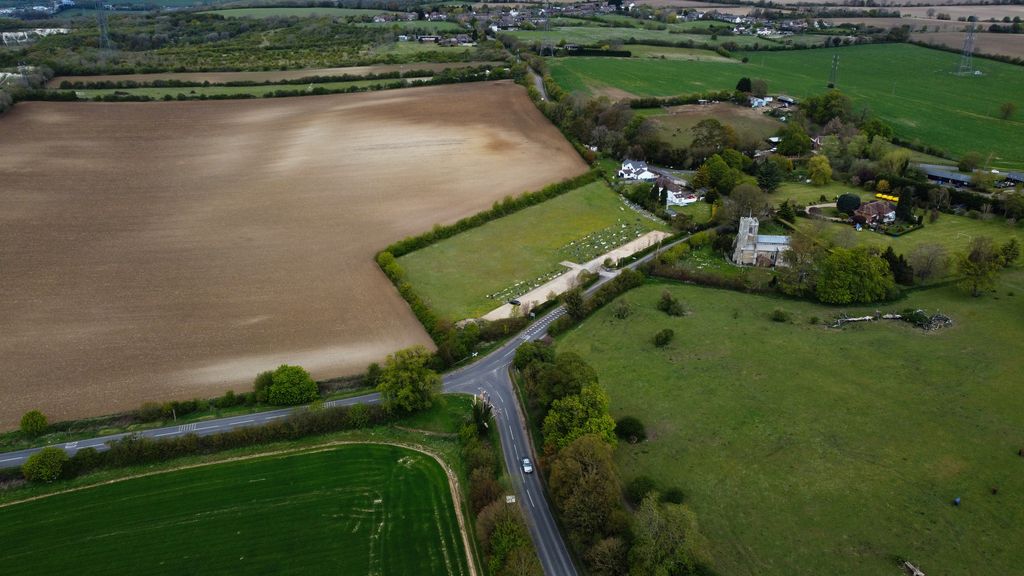 Drone shot of Central Bedfordshire countryside with fields, roads, and scattered buildings.